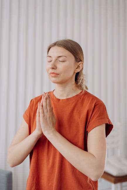 A focused woman practicing yoga at home in a bright room.