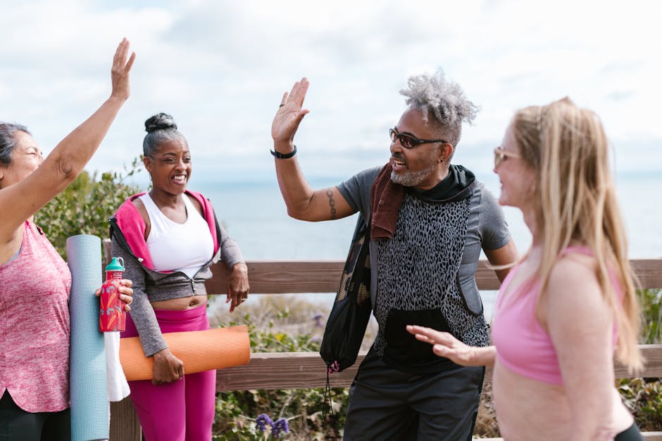 Diverse group of people smiling during a yoga practice outdoors.